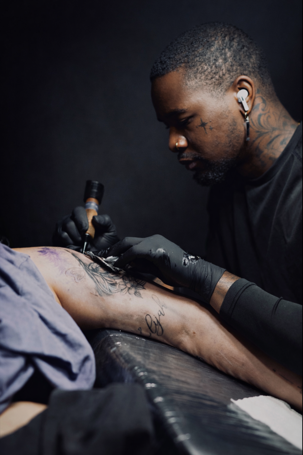 Jeremiah tattooing a client